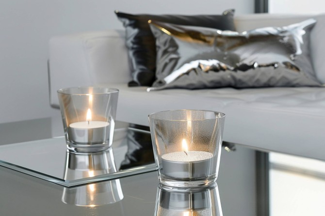 Podgrzewacze tealight 4h 100 szt. w folii p10-100 Aura przedstawione w nowoczesnej aranżacji stołu z metalowymi dodatkami.