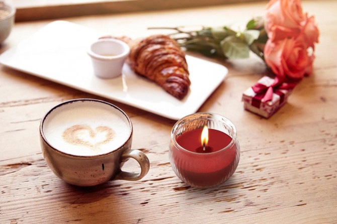 Świeca zapachowa Tajemniczy Ogród sn69-365 Aura przedstawiona obok dekoracyjnych elementów i eleganckich dodatków wnętrzarskich. Aromatyczna świeca doskonale komponuje się z nowoczesnym wystrojem domu.